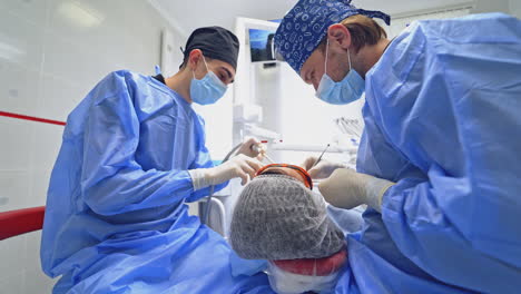dentist and assistant during teamwork. patient getting dental treatment at dental office