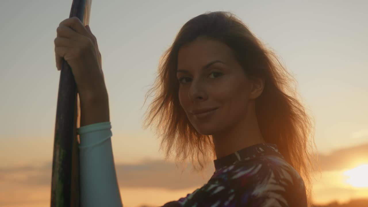 Donna che fa paddleboard al tramonto