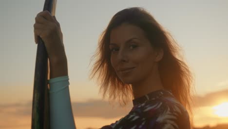 una mujer haciendo paddleboard al atardecer.