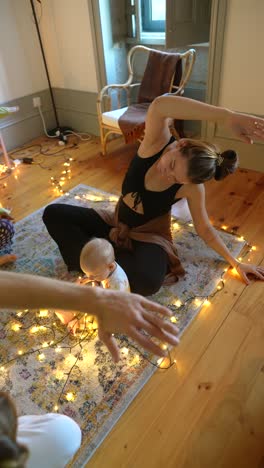 mother and baby enjoying yoga and christmas lights at home