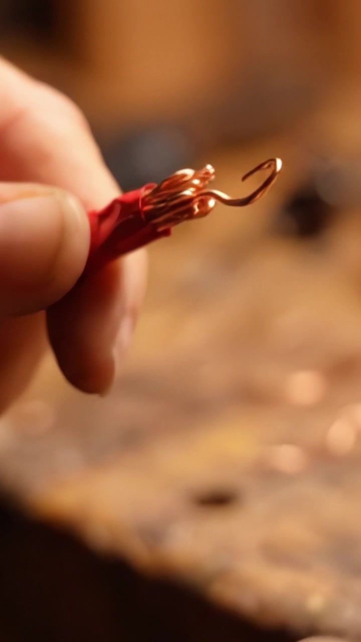 Lavorazione artigianale con fili di rame e pinze: un'esplorazione passo-passo delle tecniche di manipolazione del filo per progetti elettrici e artigianali.
