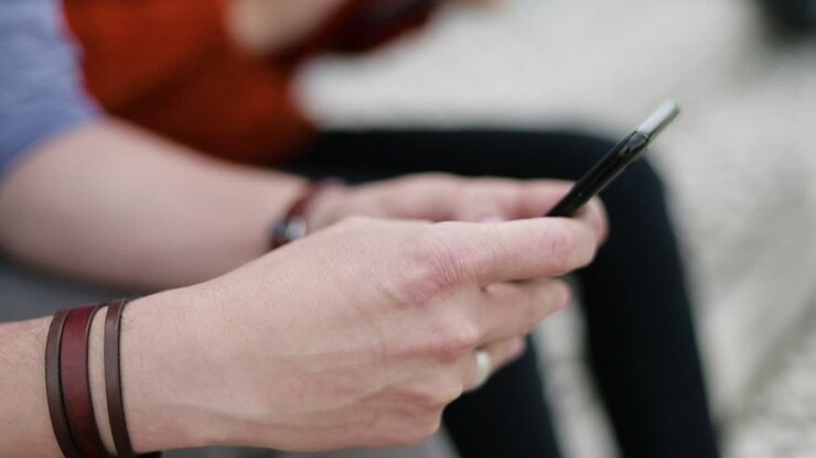 Partial view of people using digital devices outdoor