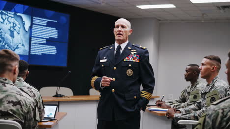 military officer giving a briefing to soldiers