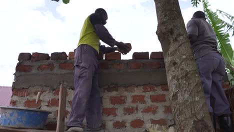 dos africanos construyendo una casa tradicional en áfrica