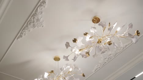 elegant floral chandelier with white petals and golden stems illuminates a luxurious interior.