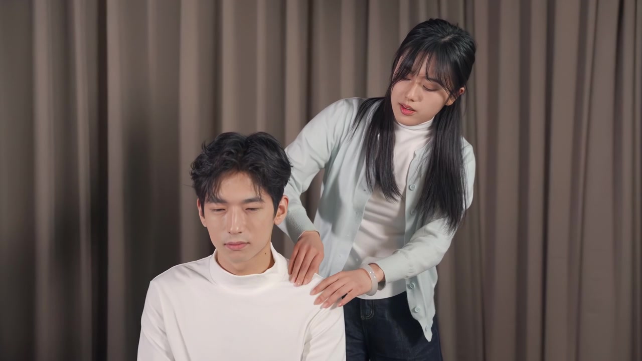 ผู้หญิงที่น่าดึงดูดใจและเอาใจใส่ (ภรรยา/แฟนสาว) กำลังนวดคอ หลัง และไหล่ให้กับชายอันเป็นที่รัก (สามี/แฟนหนุ่ม) ที่กำลังเอนหลังอยู่บนโซฟาที่บ้าน