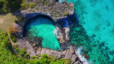 overhead view of teardrop cove in jamaica, showcasing rugged cliffs, emerald waters, and untouched natural beauty.
