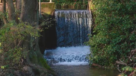 A-static-shot-of-a-flowing,-man-made-waterfall-in-the-woods