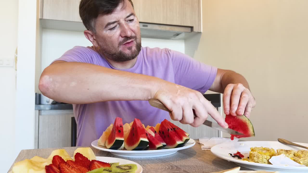 Uomo che mangia frutta in cucina