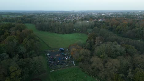 A-partial-orbit-aerial-drone-shot-over-a-garage-in-the-midst-of-the-field-and-trees-in-the-outskirts-of-Thetford,-district-of-Breckland,-Norfolk-county,-east-of-London-in-United-Kingdom