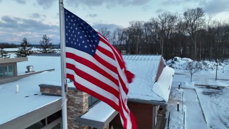 usa flag waving in winter snow scene in rural usa