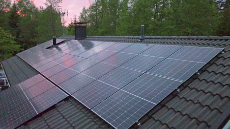 Dusk clouds mirroring from a solar cell surface on a house roof - Aerial view
