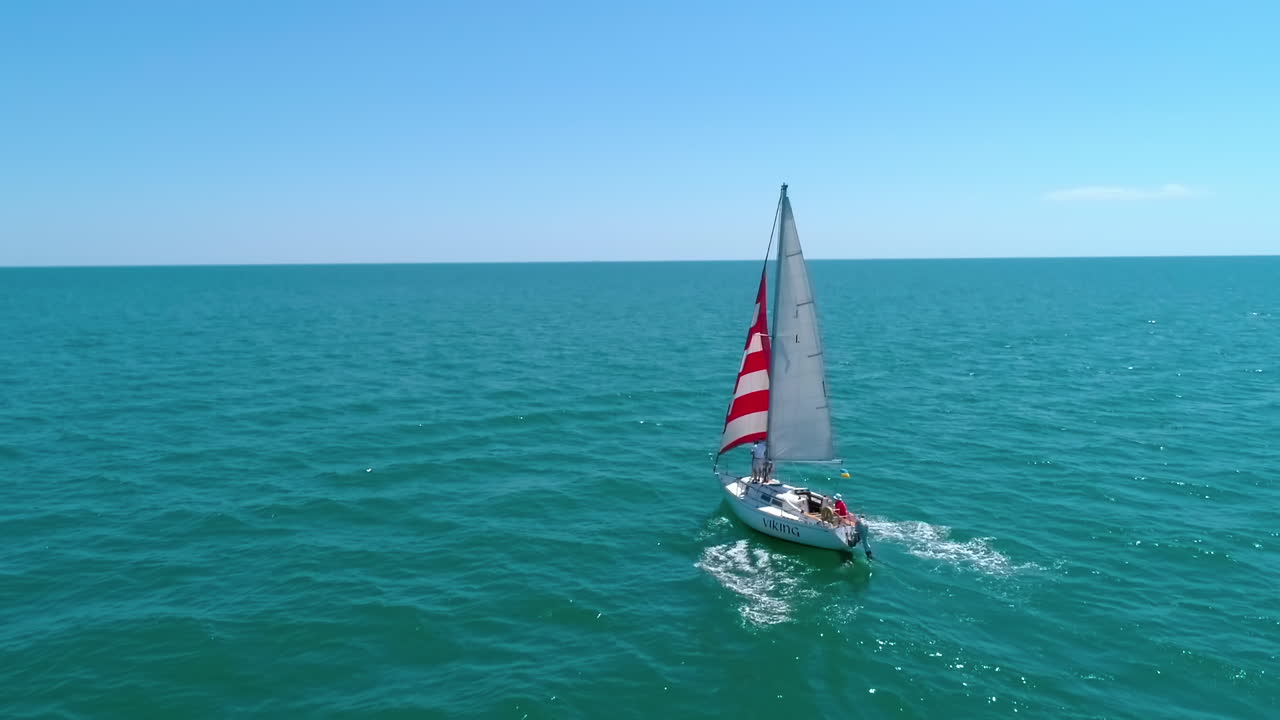 Yacht sailing in open sea. Aerial view of yacht sailing in the bay