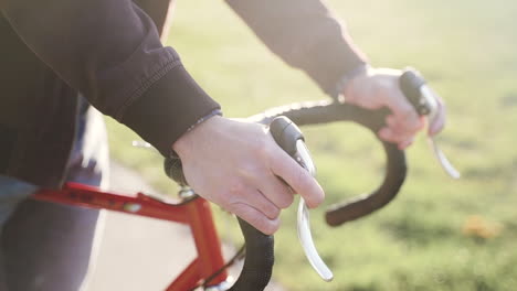 Man-on-professional-cyclist-bike,-holding-the-frame-and-preparing-to-start-during-sunshine-weather