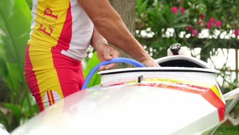 Slow-motion-close-up-of-a-Spaniard-in-a-professional-canoeing-suit-washing-his-canoe-with-a-hosepipe