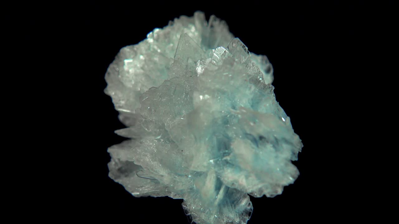 검은색 배경 앞에 밝은 파란색 미네랄 (바리트) 을 원활하게 회전시니다.