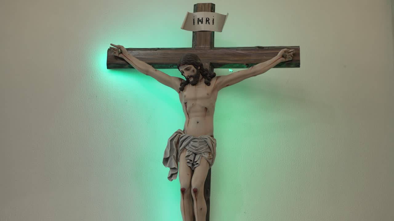 교회 에서 부드러운 초록색 빛 으로 조명 된 예수 그리스도 의 십자가