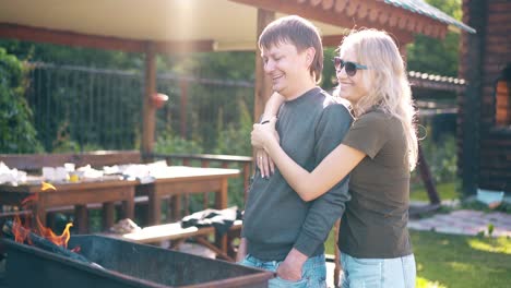 travelling young guy with girl standing near the barbecue in which coals