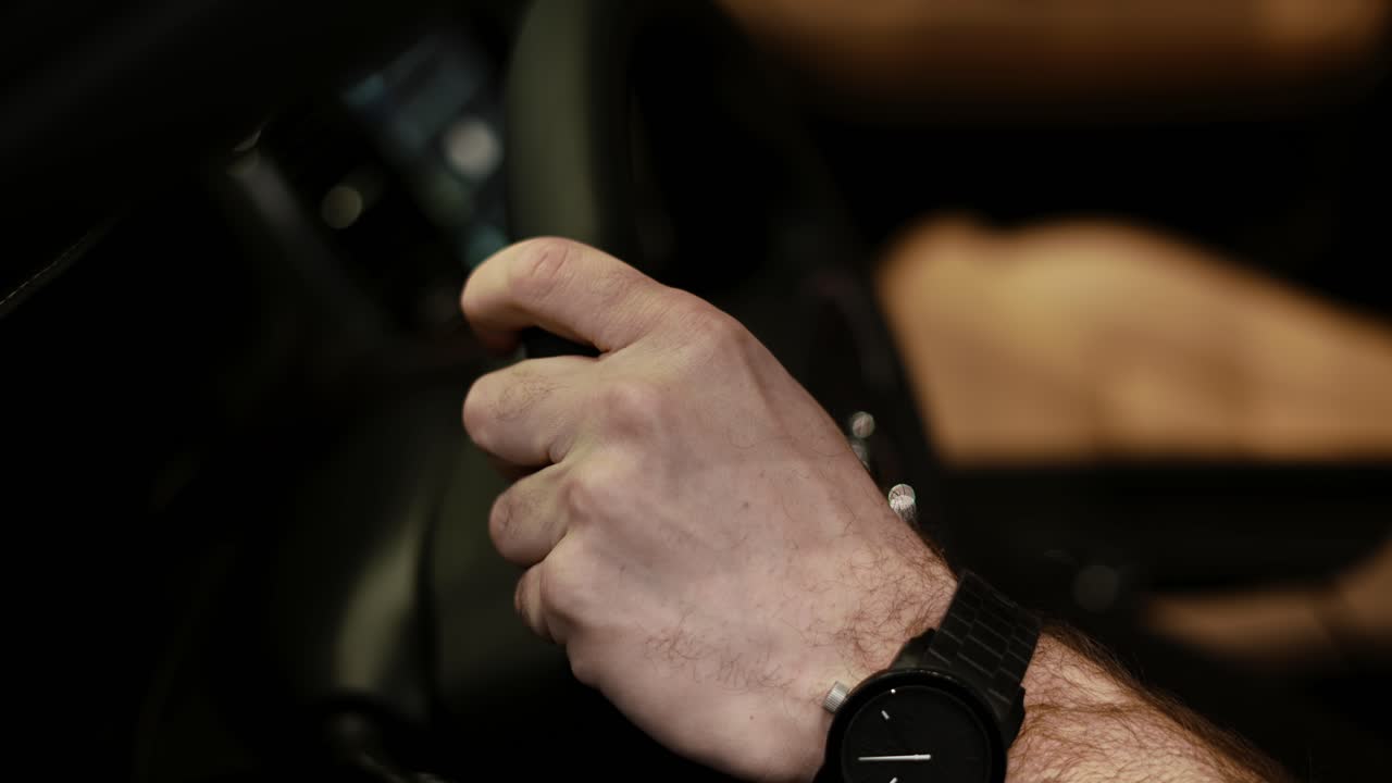 vista recortada del hombre tocando el volante en un coche de lujo