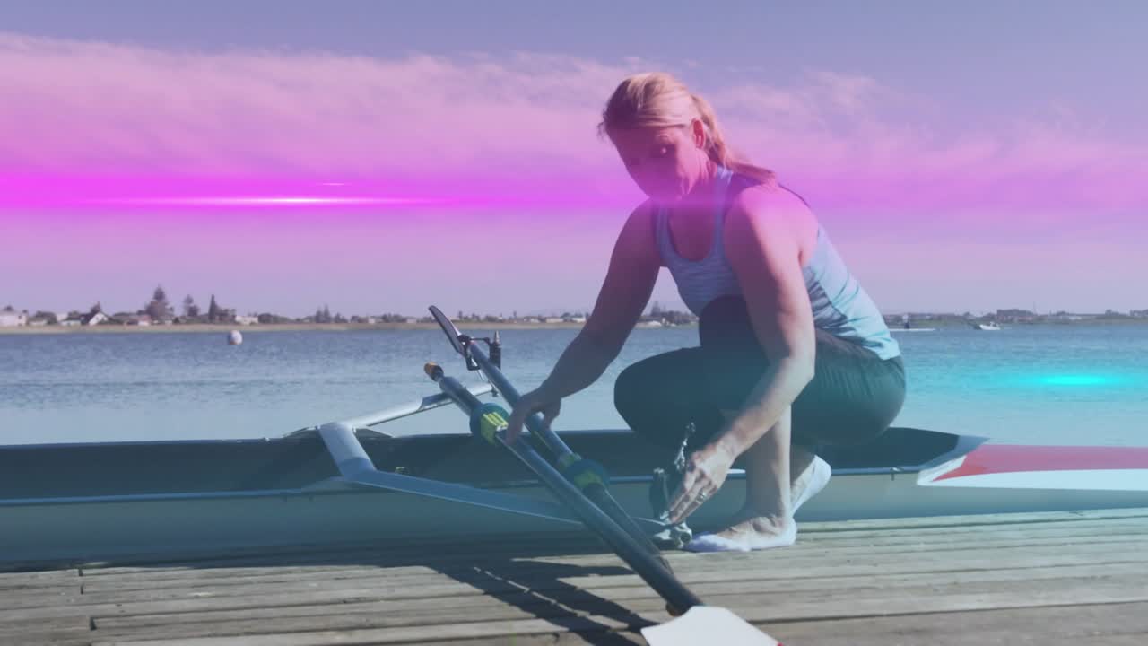 Stepping onto wooden dock, mature rowing athlete kneeling and adjusting oar rigging for boat launch