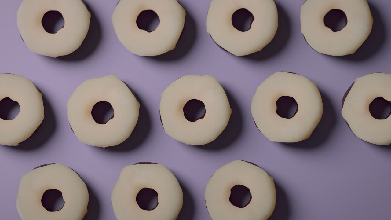 White glaze donuts on a light violet background