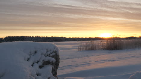 sunset over a beautiful frozen snow covered lake