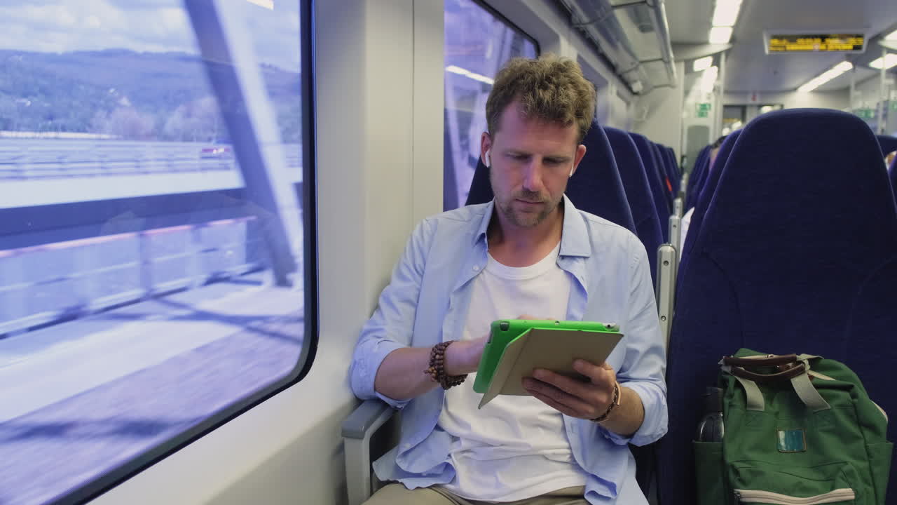 열차 에서 태블릿 을 읽는 사람