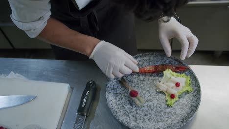 A-professional-chef-preparing-a-plate-of-prawns-in-his-kitchen