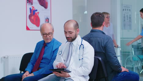 doctor discussing diagnosis with old man in hospital waiting area
