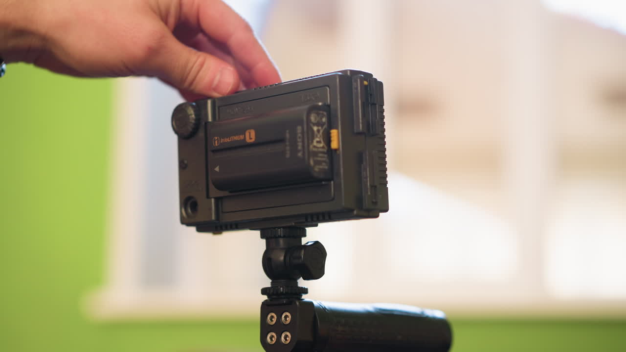 close-up of hands adjusting handheld camera gear, focusing on camera setup for video production. preparing equipment for filming, adjusting camera and lighting for professional production