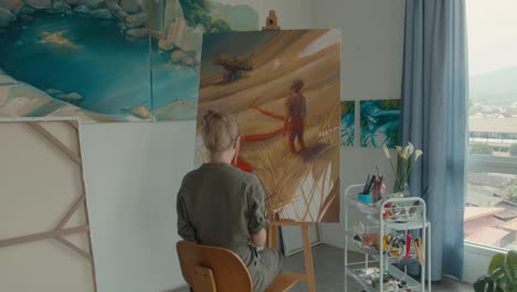 artist painting a landscape in studio