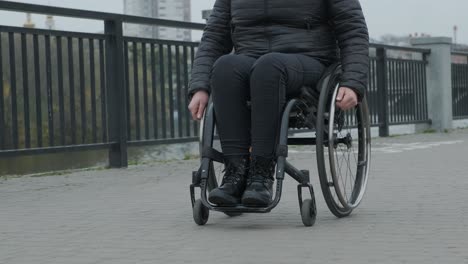 woman in a wheelchair wheeling herself outside.