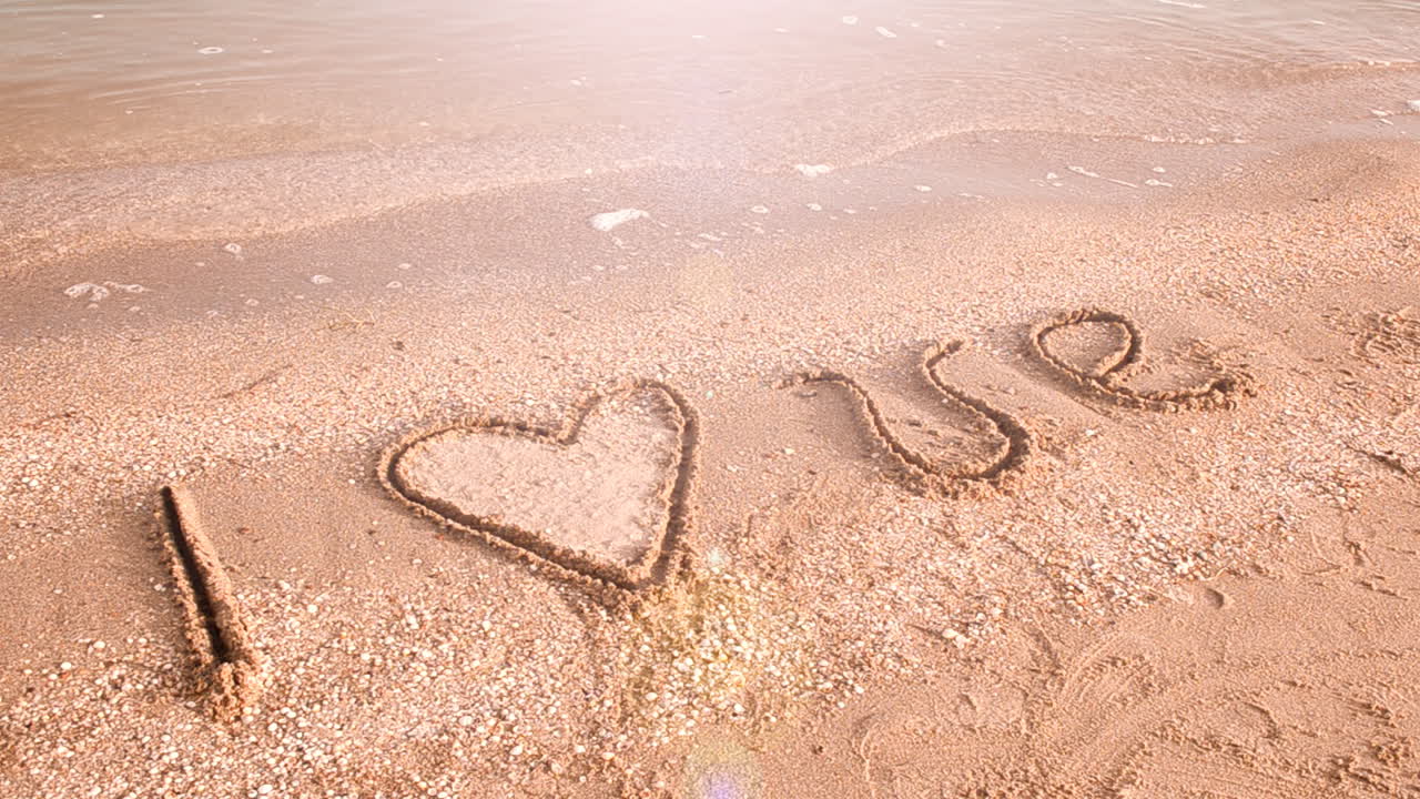Inscription on sand. I love. Shooting on the beach