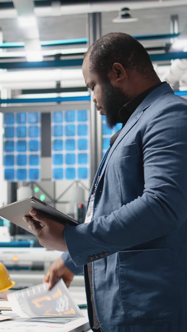Vertical Video Black master engineer overseeing photovoltaics production line in a factory