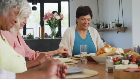 Happy-senior-diverse-people-praying-before-dinner-at-retirement-home