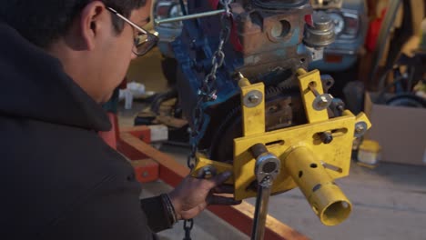 Young-mechanic-wrenching-engine-stand-bracket-to-engine