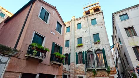 venetian buildings and canal with people walking