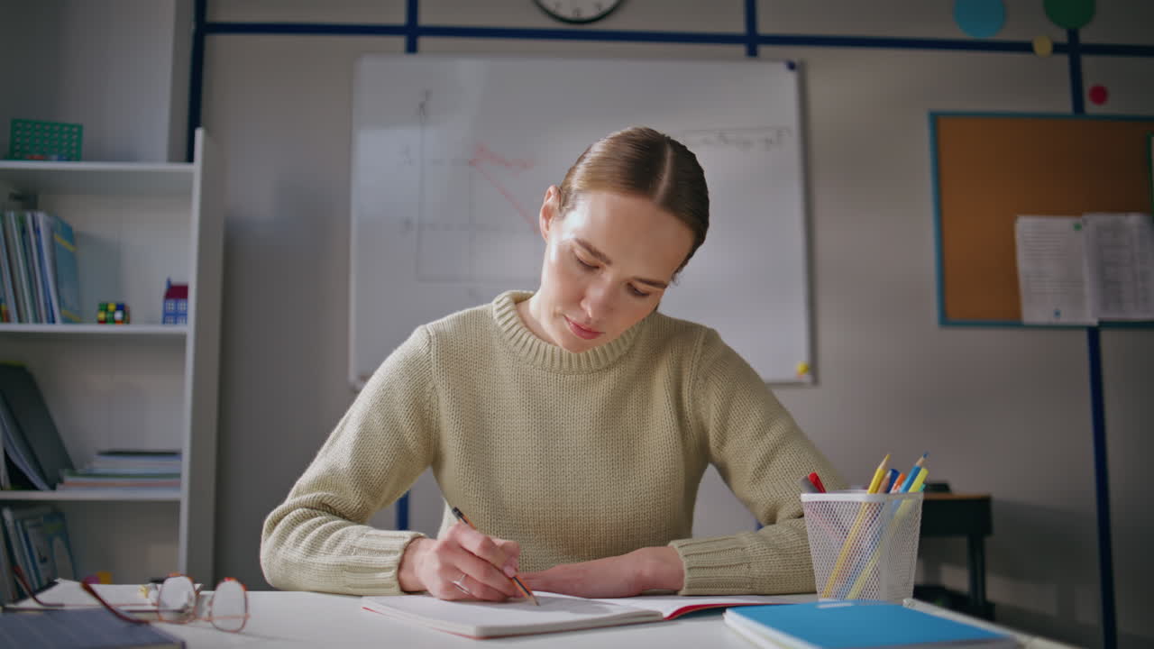 Attentive teacher checking homework working school at class room alone closeup