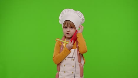 niña cocinera chef recibiendo pedidos en línea, hablando por teléfono móvil haciendo conversación con el cliente