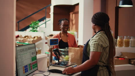 storekeeper using scale to weight all produce for client