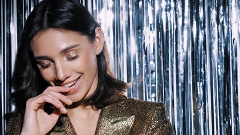 stylish woman in gold jacket with festive backdrop