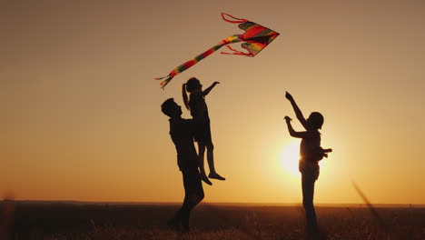 Happy-Family-Playing-With-A-Kite-At-Sunset-Mom-Dad-And-Daughter-Are-Happy-Together-4K-Video