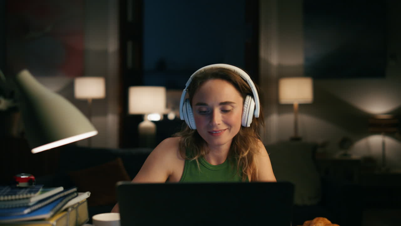 Focused girl chatting computer at home office. Headphones woman texting laptop