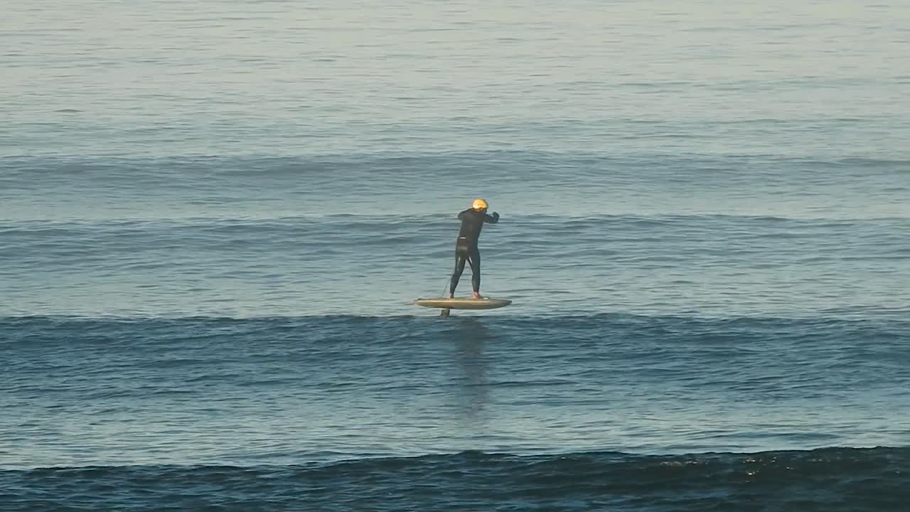 Man riding an eFoil on ocean waves