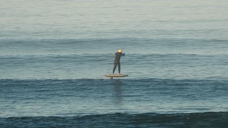 man riding an efoil on ocean waves