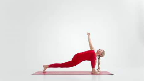 millennial woman stretching in yoga pose meditation isolated on white background in red sportswear. portrait of young female yoga practitioner posing for copy space. 4k