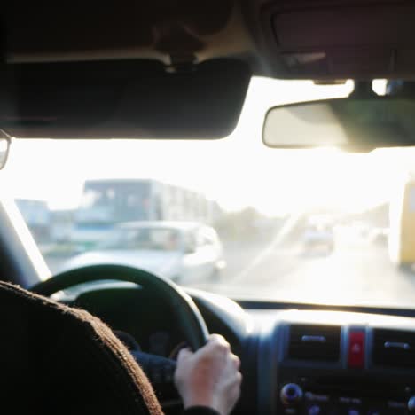 el hombre conduce un coche por la carretera el sol poniente brilla en el parabrisas