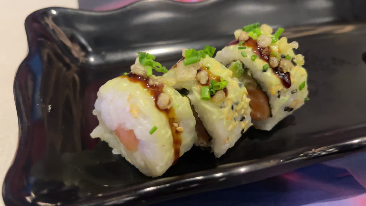Close up slow motion of a crunchy salmon avocado uramaki roll