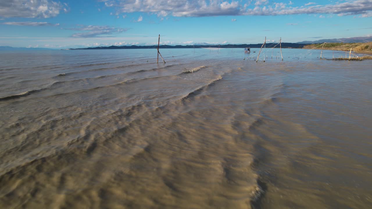 redes colgadas por cuerdas de pie en la desembocadura del río para pescar en aguas turbias del río mezclándose con agua de mar