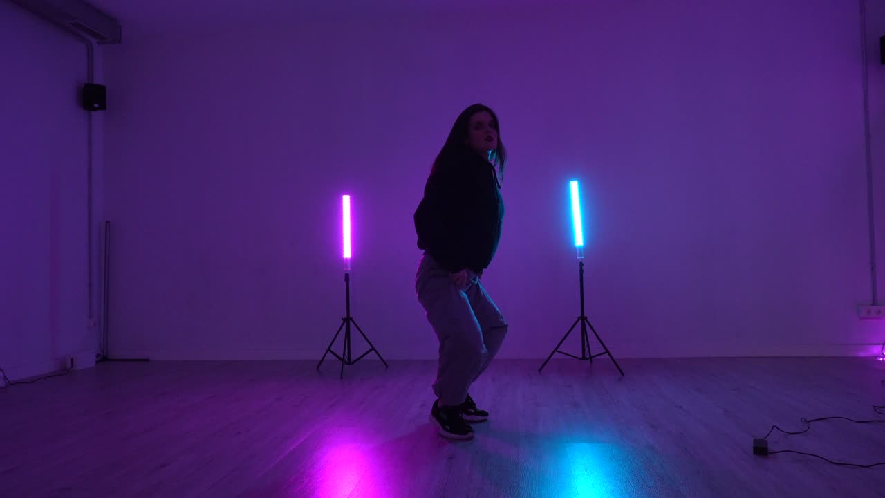 Donna che balla in uno studio di danza con luci al neon